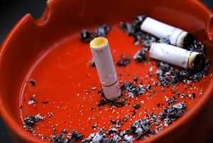 red ashtray with cigarette butts